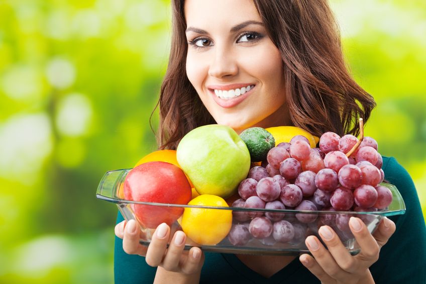 17888157 - young happy smiling woman with plate of fruits, outdoors